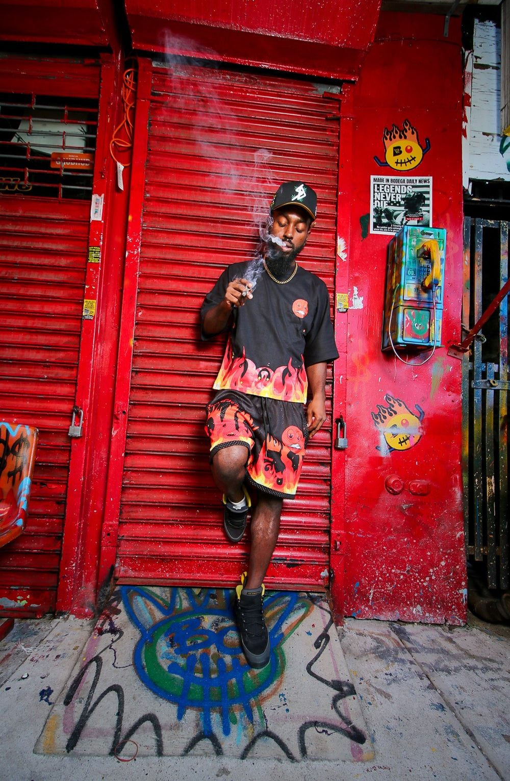 Model wearing the Mars flame tee and matching shorts against a red storefront